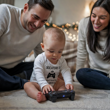 Carica l&#39;immagine nel visualizzatore di Gallery, bimbo che indossa body neonato giocatore 3 è entrato nel gioco che gioca con joypad playstation insieme a mamma e papà
